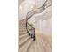 Curved staircase with black iron railing and chandelier in a bright, open foyer at 11271 Winter Cottage Pl, Las Vegas, NV 89135