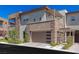 A modern townhome featuring stone accents, a balcony and a covered outdoor space near the two-car garage at 11280 Granite Ridge Dr # 1009, Las Vegas, NV 89135