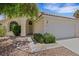 Welcoming front exterior with a two-car garage, arched entryway, and desert-style landscaping at 1230 Pagentry Dr, North Las Vegas, NV 89031