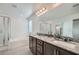 Bright primary bathroom featuring double vanity, granite countertop, separate shower, and a soaking tub at 1328 Graphite Ave, Henderson, NV 89002