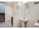 Modern half bathroom with pedestal sink, neutral color palette, and convenient access near the staircase at 1328 Graphite Ave, Henderson, NV 89002