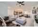 Open-concept living area with modern gray flooring, ceiling fan, and seamless flow to the kitchen and dining area at 1328 Graphite Ave, Henderson, NV 89002
