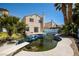 View of the backyard with a dirty pool, diving board, and the rear of a two-story home at 1345 Stokes St, Las Vegas, NV 89110