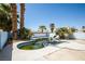 Backyard pool surrounded by palm trees, a concrete deck, and a light blue cinder block fence at 1345 Stokes St, Las Vegas, NV 89110