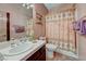 Traditional bathroom features tile floors, vanity, toilet, and shower with patterned curtain at 144 Desert Valley Dr, Boulder City, NV 89005