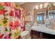 Bright bathroom featuring a floral shower curtain and a vanity with a white countertop and wood-finish cabinets at 144 Desert Valley Dr, Boulder City, NV 89005
