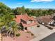 Aerial view of home with mature trees, three-car garage, and mountain views at 1587 Bermuda Dunes Dr, Boulder City, NV 89005