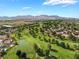 Beautiful aerial view of a golf course community with a pond and mountains in the backdrop at 1587 Bermuda Dunes Dr, Boulder City, NV 89005