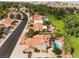 An aerial view shows a neighborhood featuring homes with pools, desert landscaping, and mature trees at 1587 Bermuda Dunes Dr, Boulder City, NV 89005