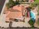 A high angle view shows a large kidney shaped pool, red rock landscaping, and a tile roof at 1587 Bermuda Dunes Dr, Boulder City, NV 89005