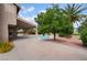 Home's backyard featuring a covered patio, desert landscaping, and mature trees creating a tranquil outdoor space at 1587 Bermuda Dunes Dr, Boulder City, NV 89005