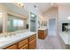 Bright bathroom featuring a soaking tub, glass shower, dual vanities, and a fireplace at 1587 Bermuda Dunes Dr, Boulder City, NV 89005