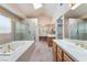 Bright bathroom featuring a soaking tub, glass shower, dual vanities and skylight at 1587 Bermuda Dunes Dr, Boulder City, NV 89005