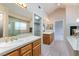 Bright bathroom featuring a soaking tub, glass shower, dual vanities, and a fireplace at 1587 Bermuda Dunes Dr, Boulder City, NV 89005
