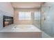 Bright bathroom featuring a soaking tub, glass shower, fireplace, and gold hardware at 1587 Bermuda Dunes Dr, Boulder City, NV 89005