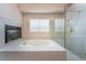 Bright bathroom featuring a soaking tub, glass shower, fireplace, and gold hardware at 1587 Bermuda Dunes Dr, Boulder City, NV 89005
