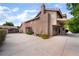 Rear exterior showcasing the home's architectural details, tiled roof, mature trees, and a spacious driveway at 1587 Bermuda Dunes Dr, Boulder City, NV 89005