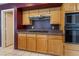 View of kitchen featuring wooden cabinets, black countertops, and built-in oven and stovetop at 1587 Bermuda Dunes Dr, Boulder City, NV 89005