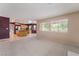 Bright living room with a fireplace opens to the kitchen with wooden cabinets and an island at 1587 Bermuda Dunes Dr, Boulder City, NV 89005