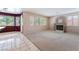 Spacious living room with plush carpeting, a modern fireplace, and natural light from large windows at 1587 Bermuda Dunes Dr, Boulder City, NV 89005