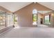 Bright living room featuring a vaulted ceiling, multiple windows, and mirrored wall at 1587 Bermuda Dunes Dr, Boulder City, NV 89005