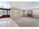 Spacious living room with plush carpeting, a modern fireplace, and natural light from large windows at 1587 Bermuda Dunes Dr, Boulder City, NV 89005