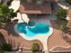 This kidney shaped pool features a jacuzzi, covered patio, and desert landscaping at 1587 Bermuda Dunes Dr, Boulder City, NV 89005