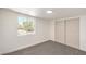 Well-lit bedroom featuring neutral carpet, a window with outside views, and double door closet at 1600 E Mcdonald Ave, North Las Vegas, NV 89030