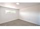 Bright bedroom featuring neutral carpet, white walls, and a bright window overlooking the yard at 1600 E Mcdonald Ave, North Las Vegas, NV 89030