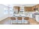 Bright kitchen features a white island with bar stool seating, wood cabinets, and stainless steel appliances at 1600 E Mcdonald Ave, North Las Vegas, NV 89030