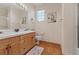 Well-lit bathroom featuring a double sink vanity, tile countertops, wood floors, and a framed mirror at 175 Palta Ct, Henderson, NV 89074