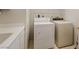 Functional laundry room with washer, dryer, a utility sink, and wire shelving for optimal organization and storage at 175 Palta Ct, Henderson, NV 89074