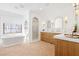 Bright bathroom with a freestanding tub, walk-in shower, double vanities and brick floors at 1990 Country Cove Ct, Las Vegas, NV 89135