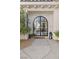 Inviting front entrance featuring a striking arched doorway, stone pathway, and lush landscaping at 1990 Country Cove Ct, Las Vegas, NV 89135