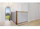Well-lit staircase with wood and wrought iron railing, highlighted by a large arched window with views of the yard at 1990 Country Cove Ct, Las Vegas, NV 89135