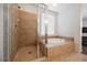 Bright bathroom features a tub and a tiled shower with glass door at 2008 Royal Gardens Pl, North Las Vegas, NV 89084