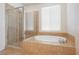 Bathroom with a glass-enclosed shower and a luxurious soaking tub at 2008 Royal Gardens Pl, North Las Vegas, NV 89084