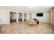A spacious living room with tile flooring, a wooden table, and a wall-mounted TV at 2008 Royal Gardens Pl, North Las Vegas, NV 89084