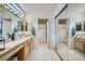 Bright bathroom features dual sinks, wood cabinets, and tile flooring at 2401 Ocean Edge Ct, Las Vegas, NV 89134