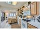 Bright kitchen featuring white appliances, wood cabinets, and breakfast bar area at 2401 Ocean Edge Ct, Las Vegas, NV 89134