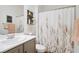Cozy bathroom showcasing a floral shower curtain, decorative shelving, and a neutral color palette at 2616 Red Planet St, Henderson, NV 89044