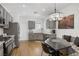 Modern eat-in kitchen with gray cabinets, granite countertops, stainless steel appliances, and stylish light fixture at 2616 Red Planet St, Henderson, NV 89044