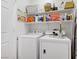 Functional laundry area with white washer and dryer, complemented by ample shelving for storage at 2616 Red Planet St, Henderson, NV 89044