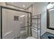 Modern bathroom with tiled walk-in shower featuring a glass enclosure, and a vanity with decorative mirror at 2708 Beaver Creek Ct # 202, Las Vegas, NV 89117