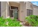 Inviting front entrance with a green door, desert landscaping, and a well-lit porch at 2714 Bridgepointe Dr, Las Vegas, NV 89121