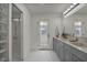 Modern bathroom with double vanity, marble countertops, and a glass-enclosed shower with marble surround at 3421 Rochelle Ct, Las Vegas, NV 89121