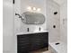 Modern bathroom featuring double sink vanity, decorative mirror, and walk-in shower with marble surround at 3622 Covewick Dr, North Las Vegas, NV 89032