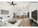 Bright living room features wood floors, white walls, ceiling fan, and white sofa at 3622 Covewick Dr, North Las Vegas, NV 89032