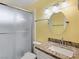 Bright bathroom featuring granite countertop, round mirror, and tub-shower with sliding glass door at 3747 N Braewood South Ave, Las Vegas, NV 89120
