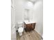 Powder room with wood-look flooring, a sink, and a toilet at 3829 N Mayfield Ranch Rd, Pahrump, NV 89060